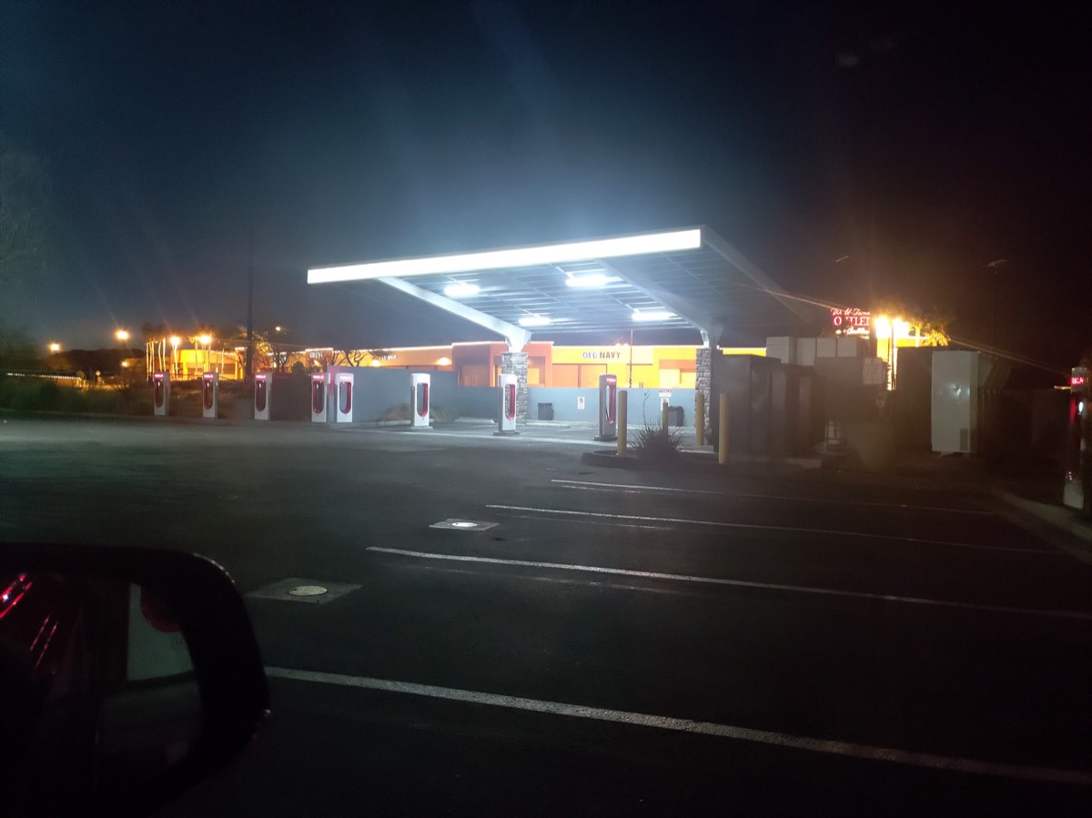 夜间特斯拉超充站,顶棚带白灯带,奥特莱斯区域