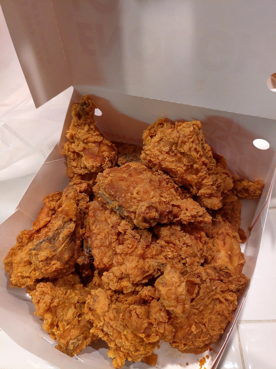 白色外卖盒里码着金黄酥脆的炸鸡,桌上光线暖黄