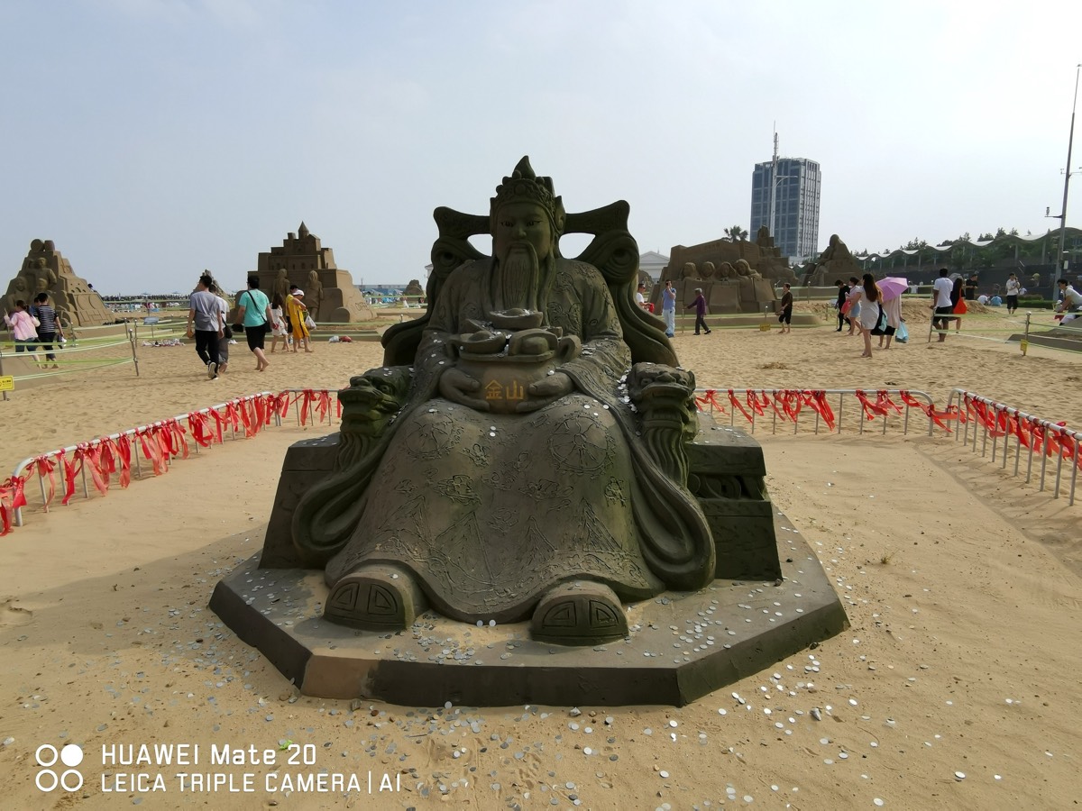 财神沙雕,双手捧聚宝盆刻「金山」二字,红绸围栏